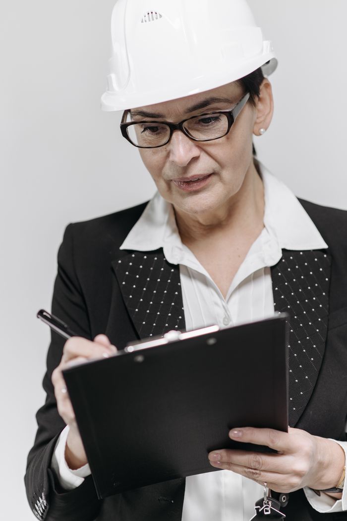 Confident female engineer in formal attire reviewing paperwork with focus.